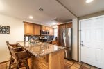 kitchen with breakfast bar with granite counters, stainless steel appliances, decorative tile back splash